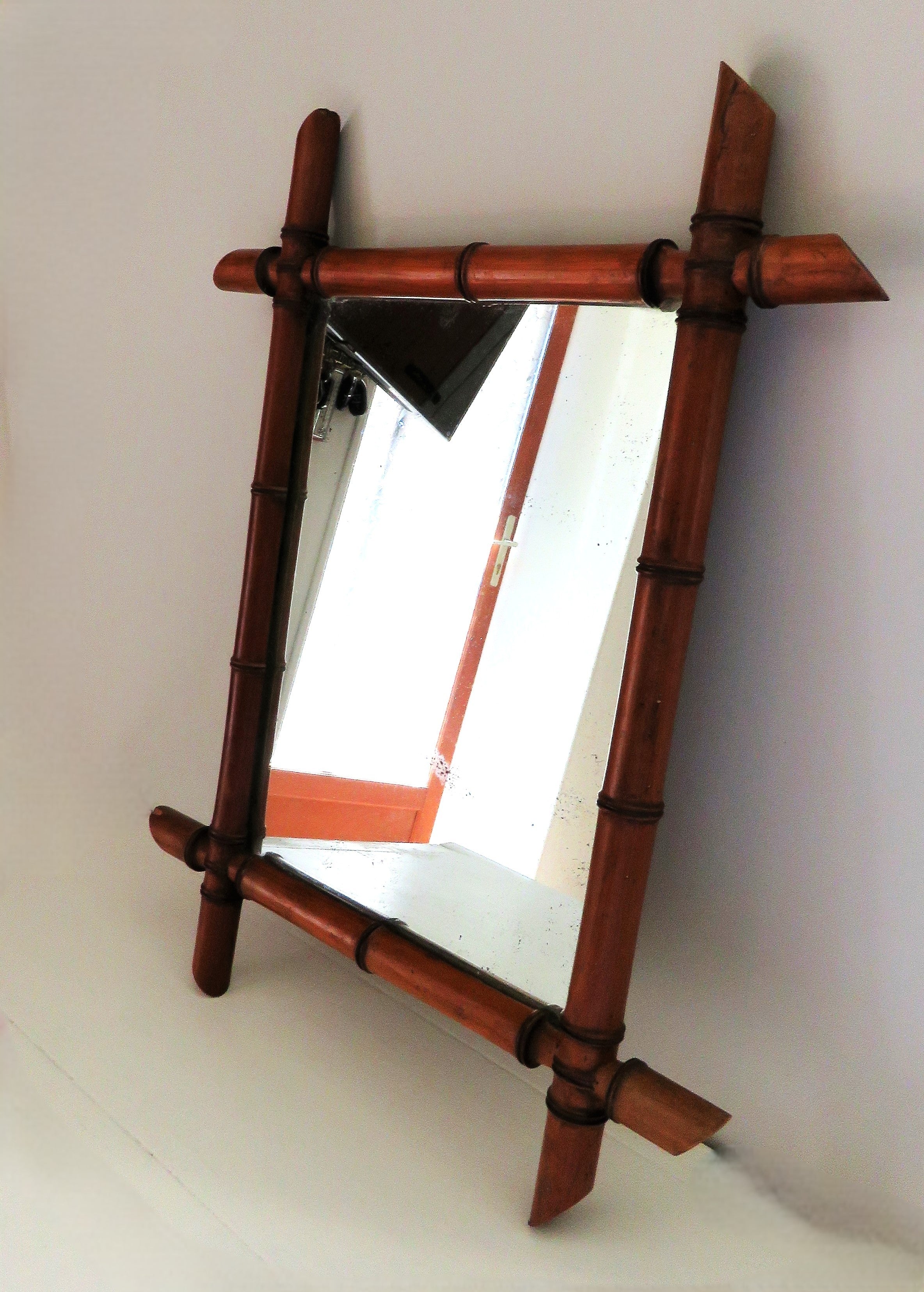 Wooden-framed mirror with a bamboo design on a white background