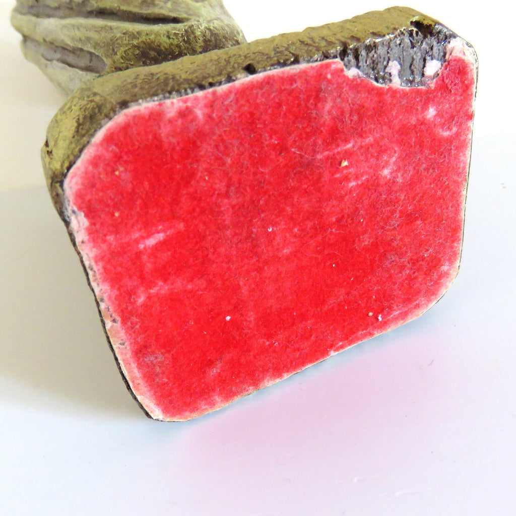 bottom of a figurine with chip on white background
