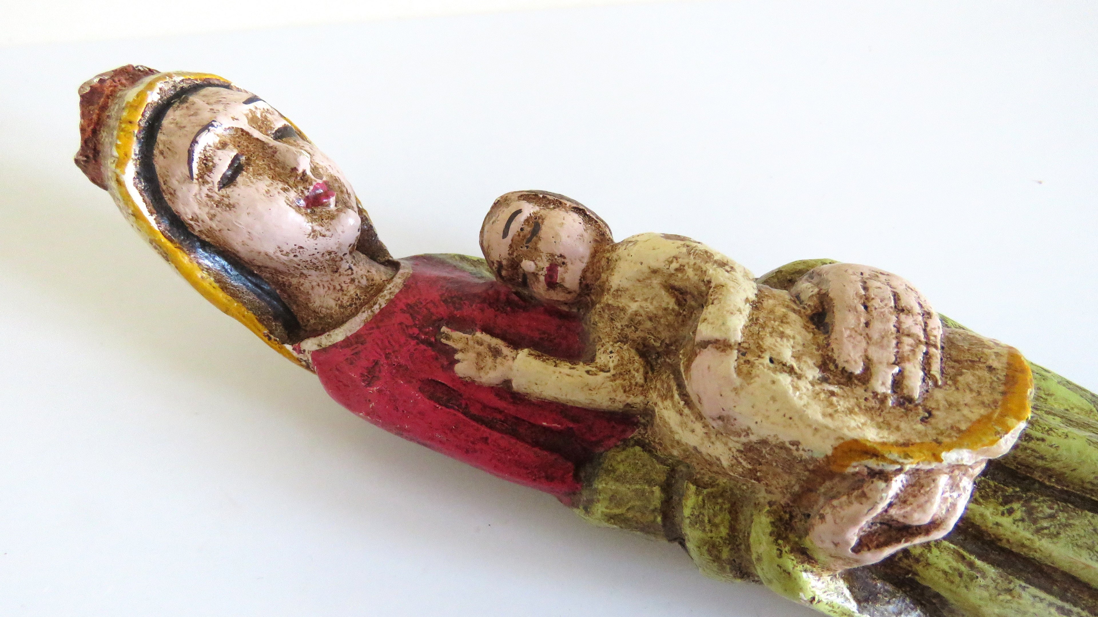 Upper part of a virgin mary figurine on white background