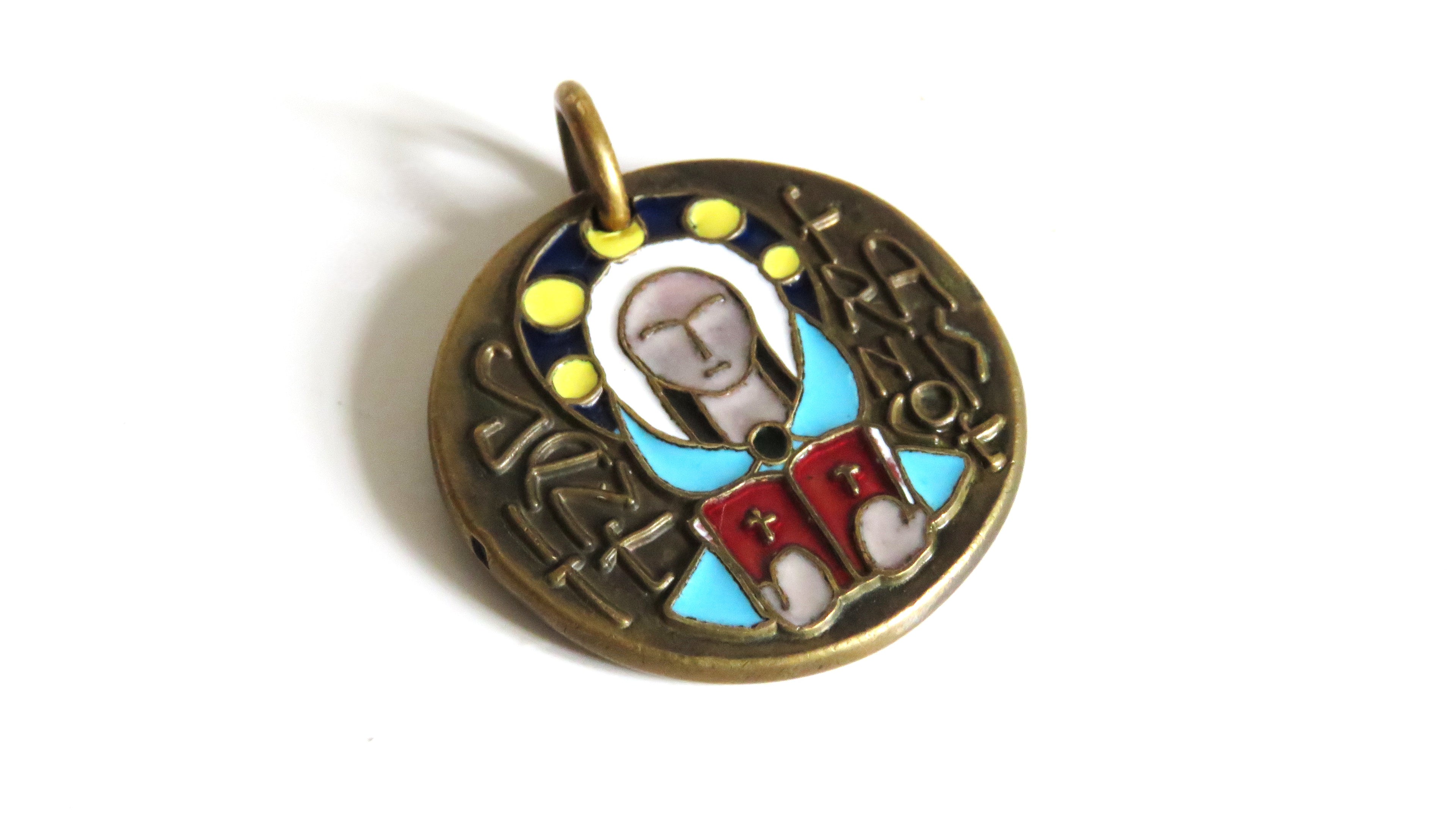 A round antique-style metal pendant with an embossed figure and colorful enamel details in blue, red, yellow, and white, set against a plain white background.