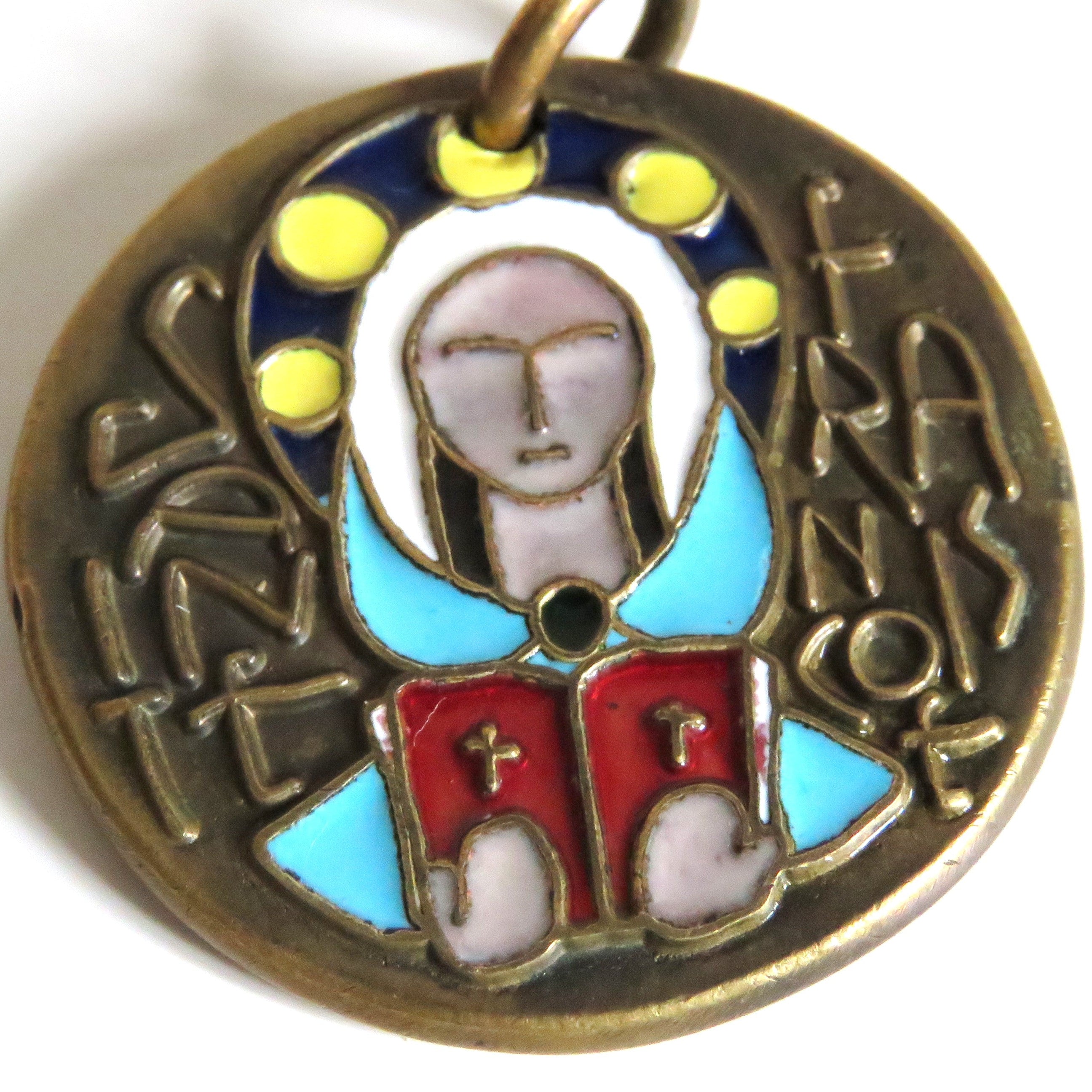A round antique-style religious pendant or medallion with a bronze-toned metal base, featuring enamel details in light blue, red, white, and yellow, with a hanging loop at the top.