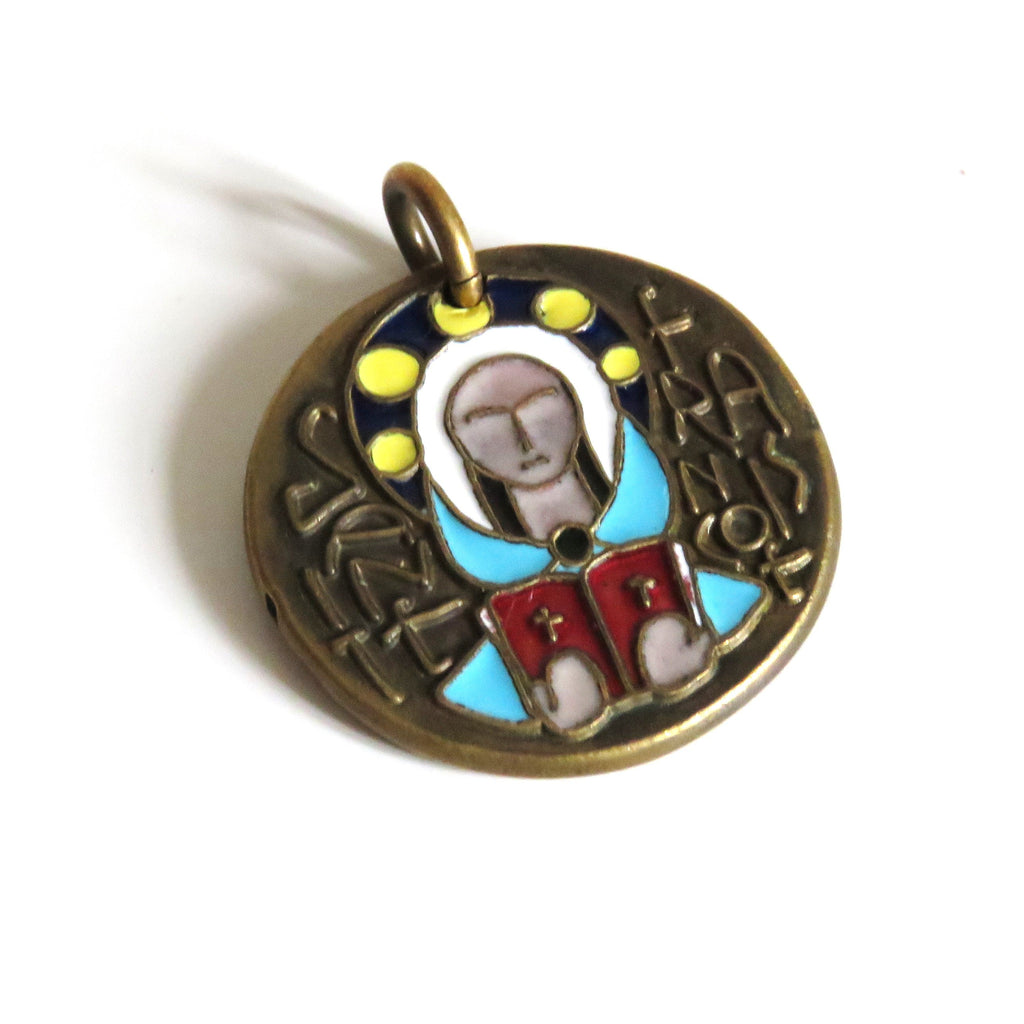 A round antique bronze religious pendant featuring an enamel depiction of the Saint Francois holding a red book, set against a plain white background.