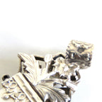 hallmark on the top of a silver crucifix