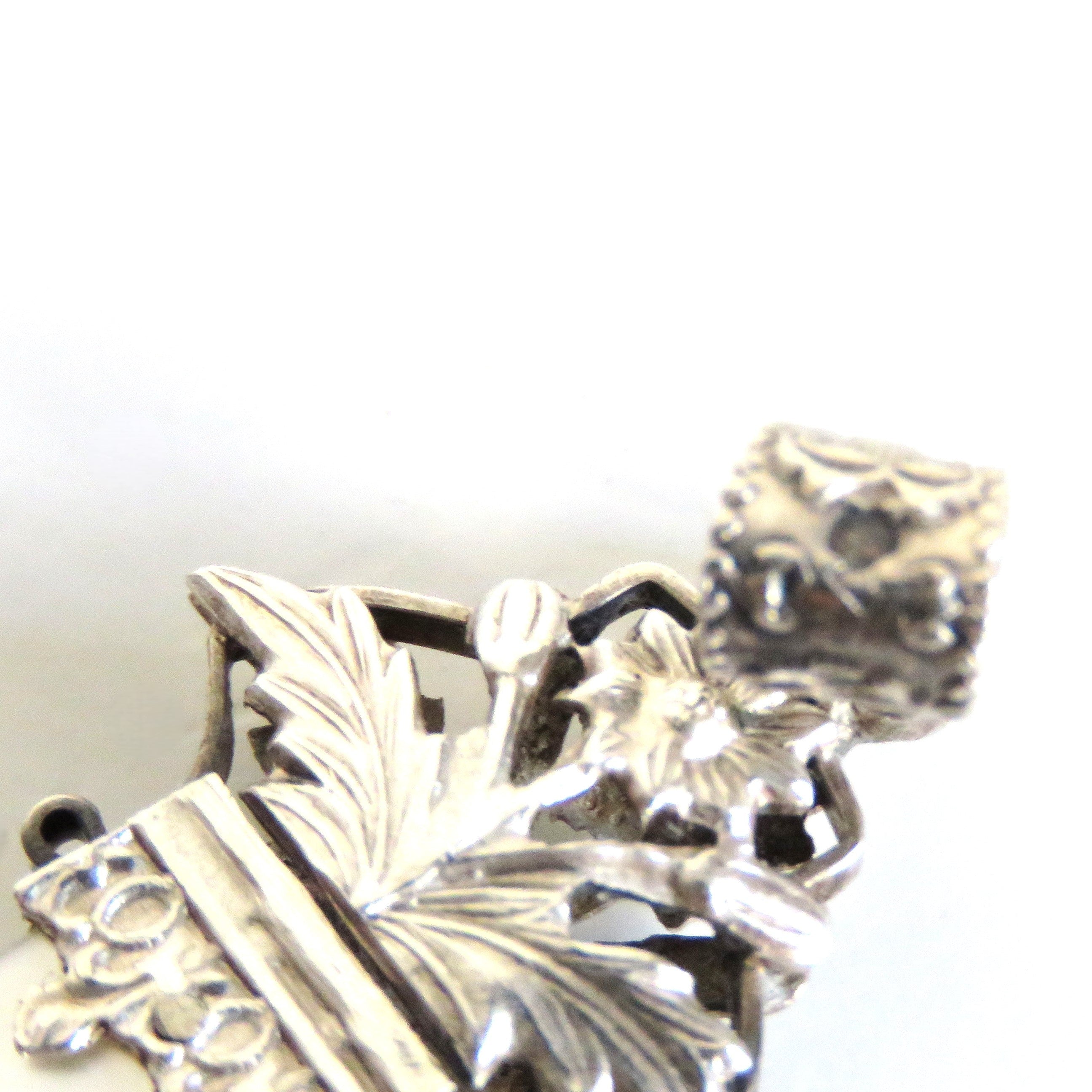 hallmark on the top of a silver crucifix