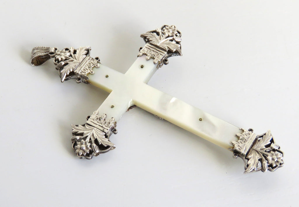 Decorative cross with ornate silver top on a white background