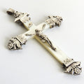 Decorative silver cross with a figure on a white background