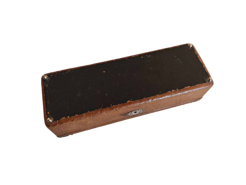 A vintage rectangular wooden box with a black top and a brown wood-grain side, photographed on a white painted wooden surface.