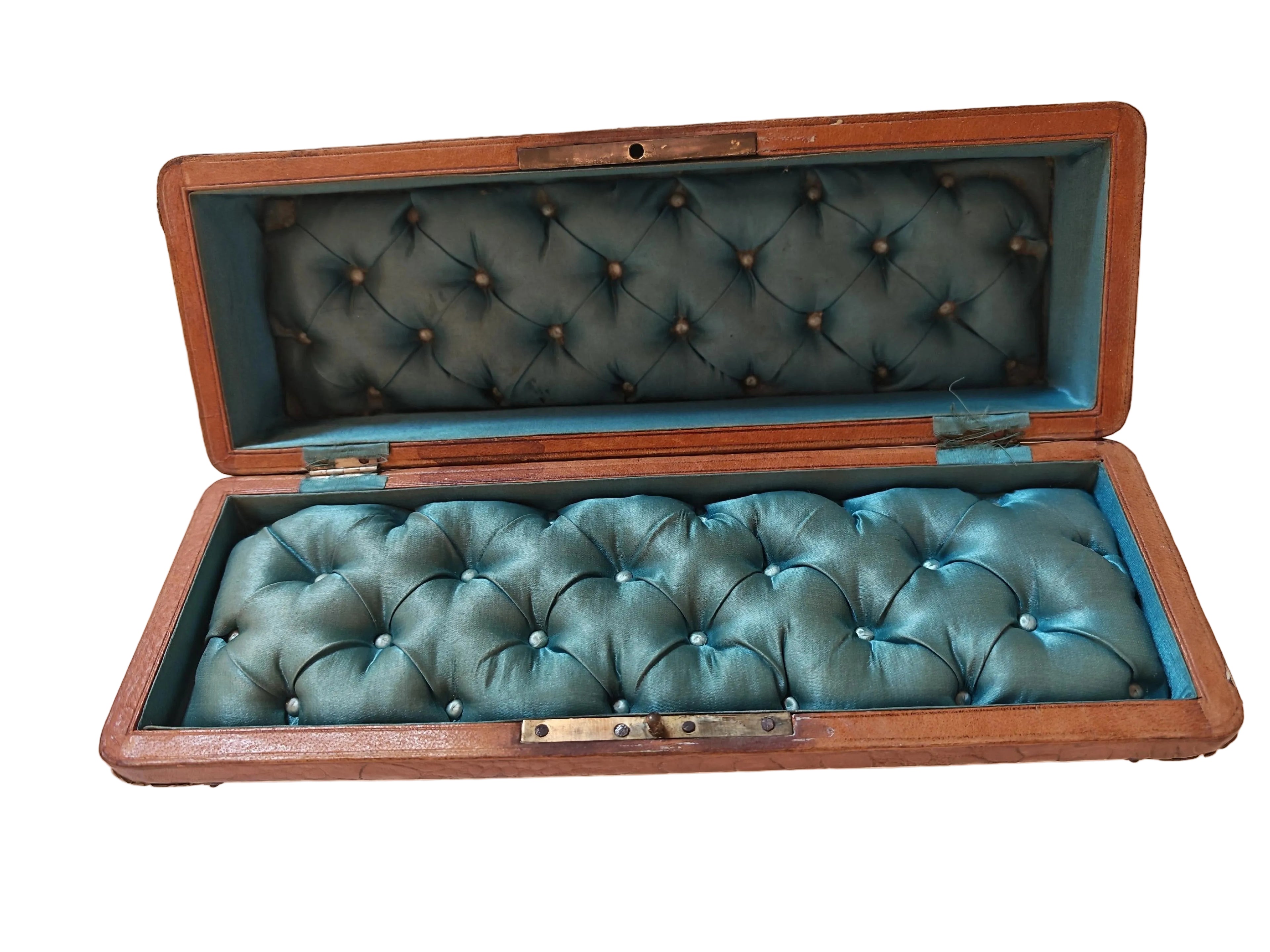 An open wooden coffin-shaped box with tufted teal upholstery inside, photographed against a plain off-white wall.